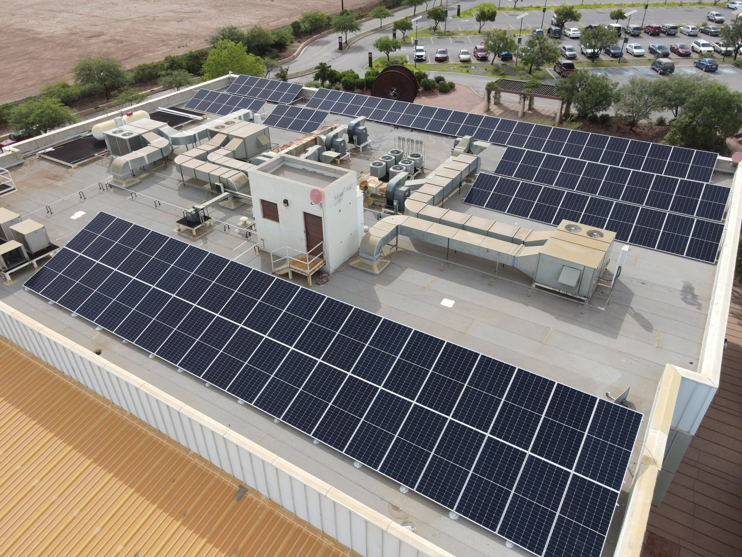 Azotea de un edificio de Grupo México en Cananea con filas de paneles solares junto a los equipos de aire acondicionado