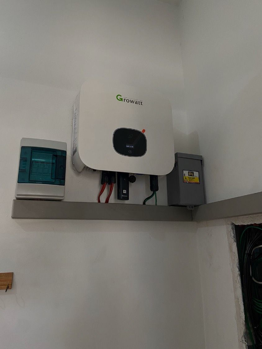 Inversor Growatt montado en un muro interior, sobre una repisa, entre el centro de carga y el desconectador