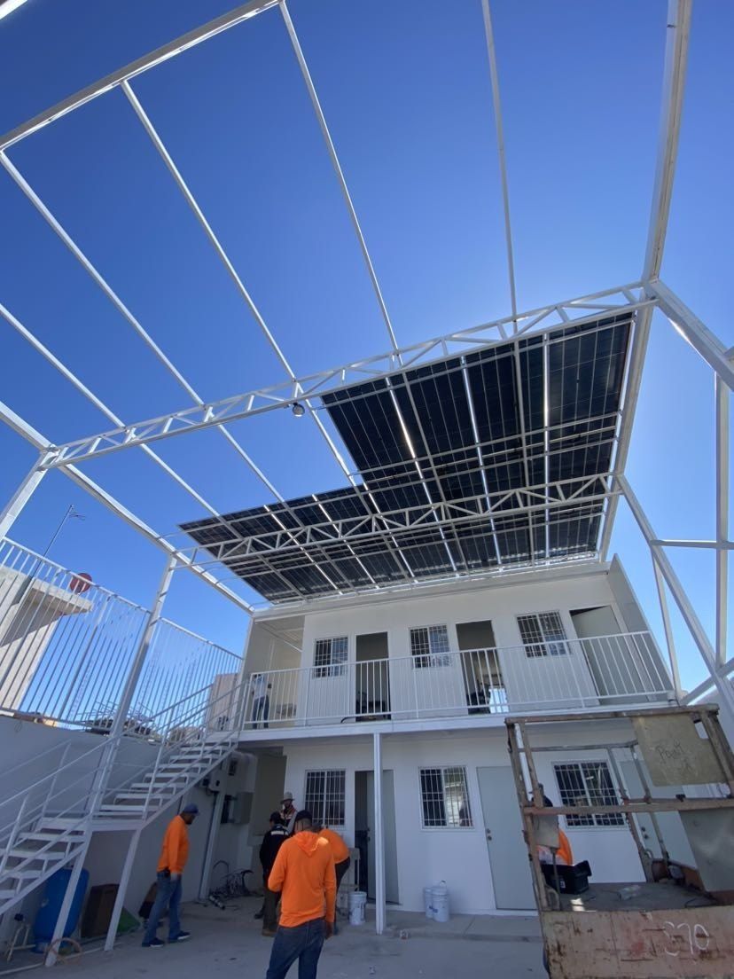 Estructura metálica elevada con paneles solares sobre la azotea de un negocio en Hermosillo, con la cuadrilla trabajando abajo