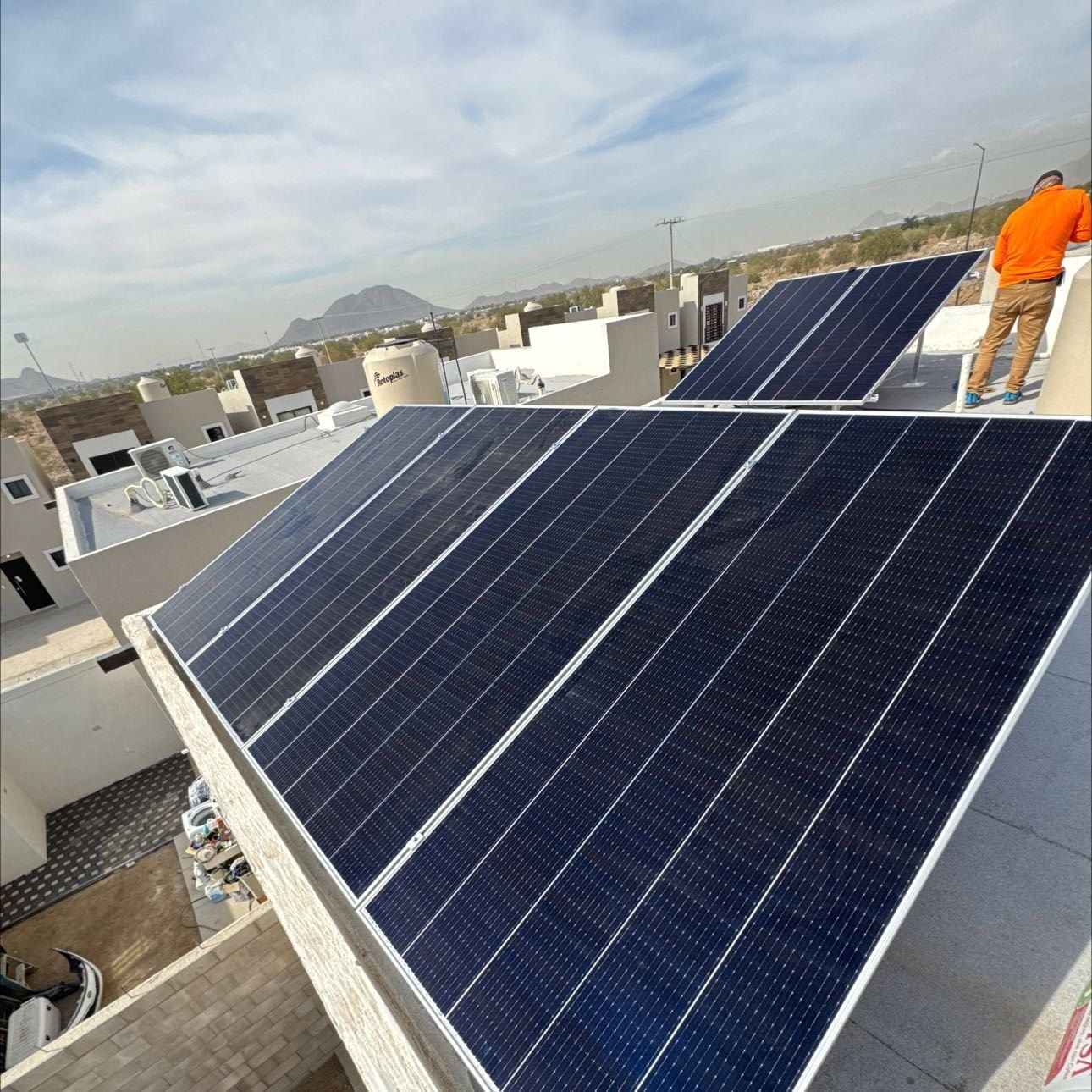 Instalador de Solarix junto a una fila de paneles recién montados en una azotea
